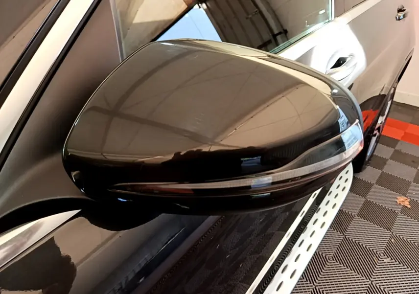 Gros plan sur le rétroviseur droit noir brillant du Mercedes GLC 300 E AMG Line gris foncé, vue latérale partielle.