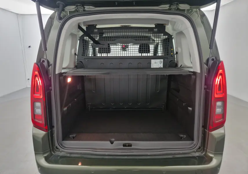 Vue arrière de l'Opel Combo Life vert Sirkka avec coffre ouvert et grille de séparation visible derrière les sièges.