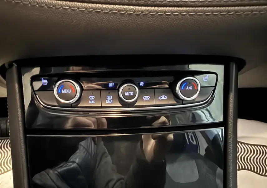 Gros plan sur la console centrale de l’Opel Grandland X 1.6 Hybrid Turbo 2021, avec commandes de climatisation et sièges chauffants.