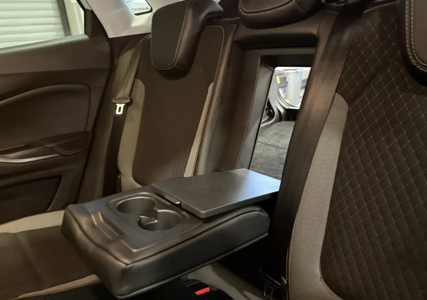 Vue intérieure du siège arrière droit de l’Opel Grandland X blanc, avec accoudoir central et trappe de chargement ouverte.