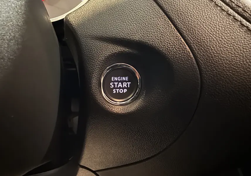 Gros plan sur le bouton moteur start/stop entouré de cuir noir dans l’habitacle de l’Opel Grandland X hybride rechargeable.