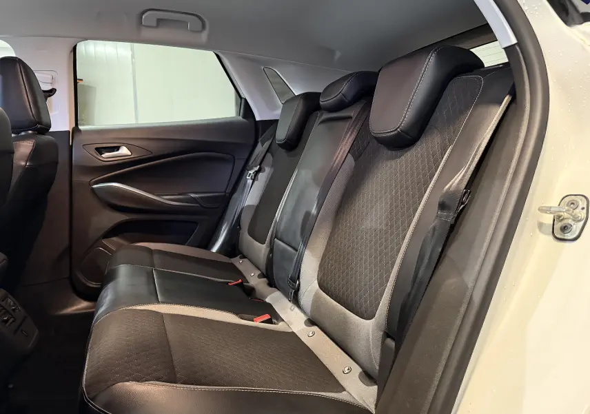 Vue intérieure côté droit des sièges arrière en cuir noir et tissu gris du Opel Grandland X blanc de 2021.