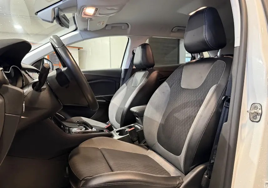Vue intérieure côté conducteur de l’Opel Grandland X blanc, sièges avant en cuir noir et tissu gris avec surpiqûres.