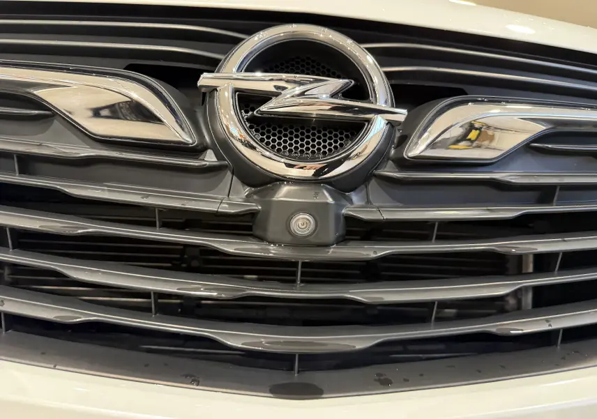 Gros plan sur la calandre avant noire et chrome avec logo Opel sur un Opel Grandland X blanc.