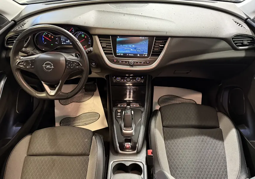 Vue intérieure de l’Opel Grandland X 1.6 Hybrid Turbo 2021, tableau de bord noir avec écran tactile central et volant multifonction.
