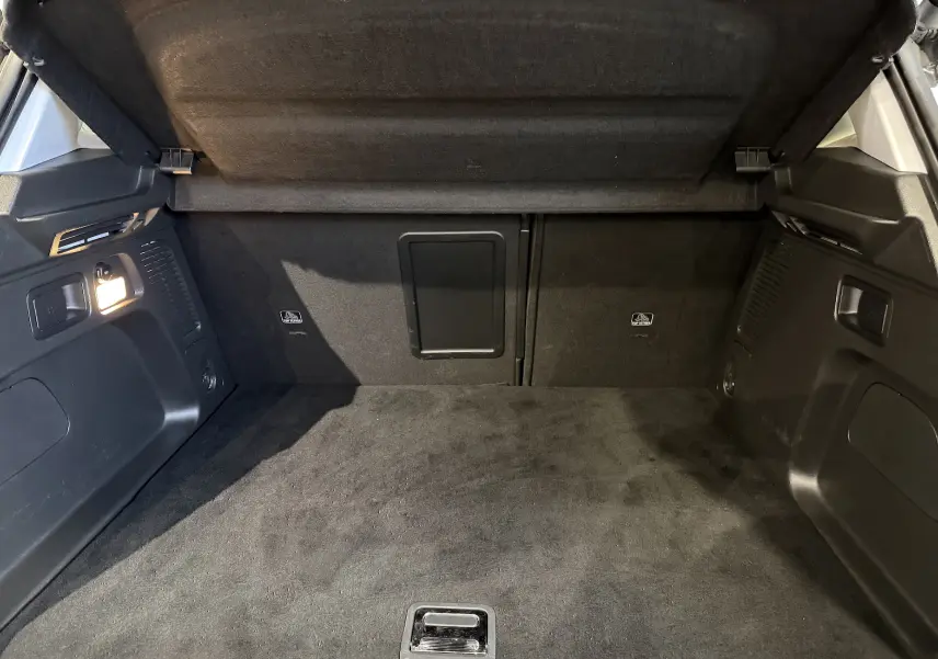 Coffre ouvert d’un Opel Grandland X blanc, vue intérieure montrant un espace de chargement propre et bien éclairé.