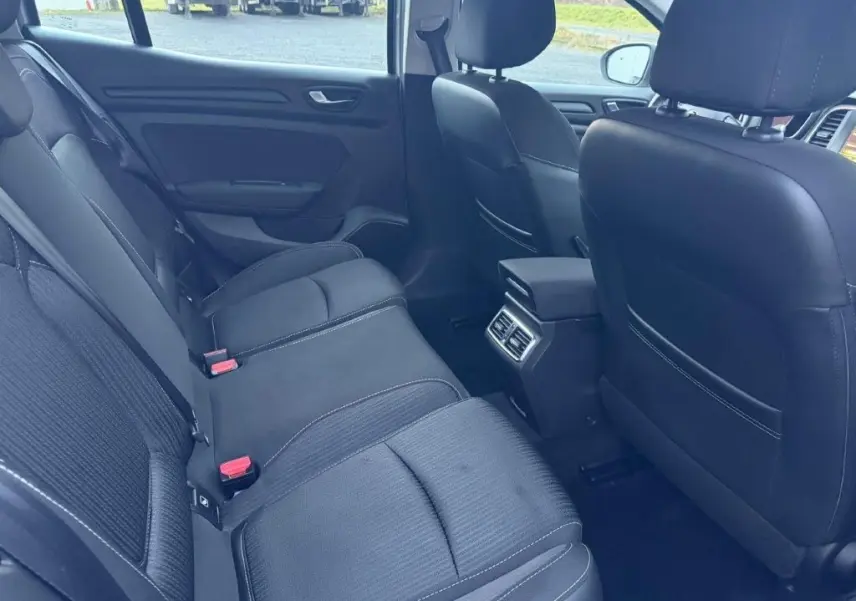 Vue intérieure arrière côté droit de la Renault Mégane Business gris alu, montrant les sièges arrière et les aérateurs centraux.