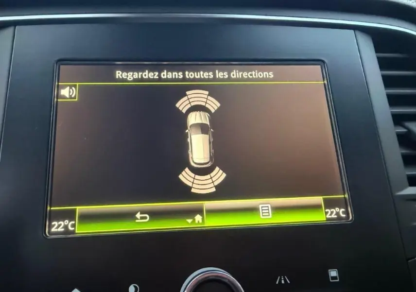 Écran central de la Renault Mégane Business affichant l'alerte de surveillance des angles morts et la température à 22°C.