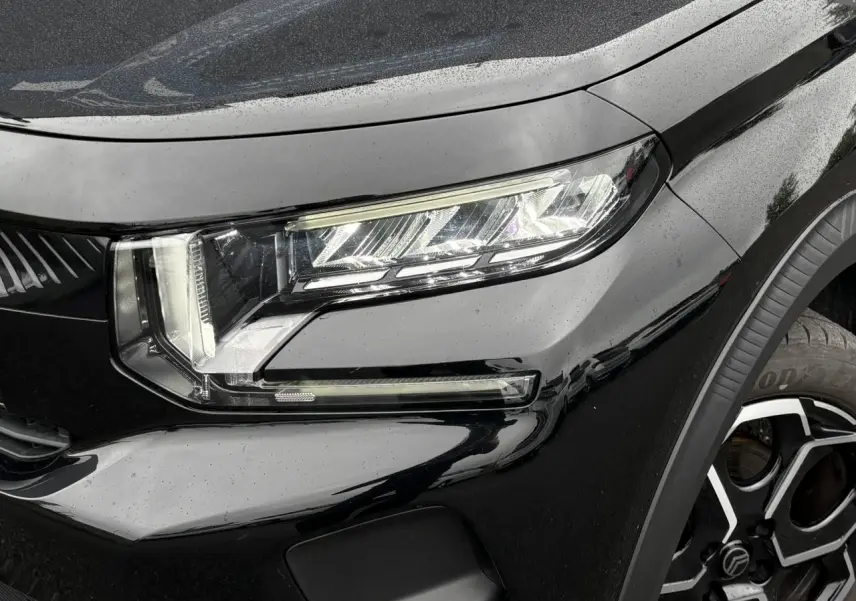 Gros plan sur le phare avant droit et la roue alliage 17" de la Citroën C3 Turbo 100 Max noir Perla.