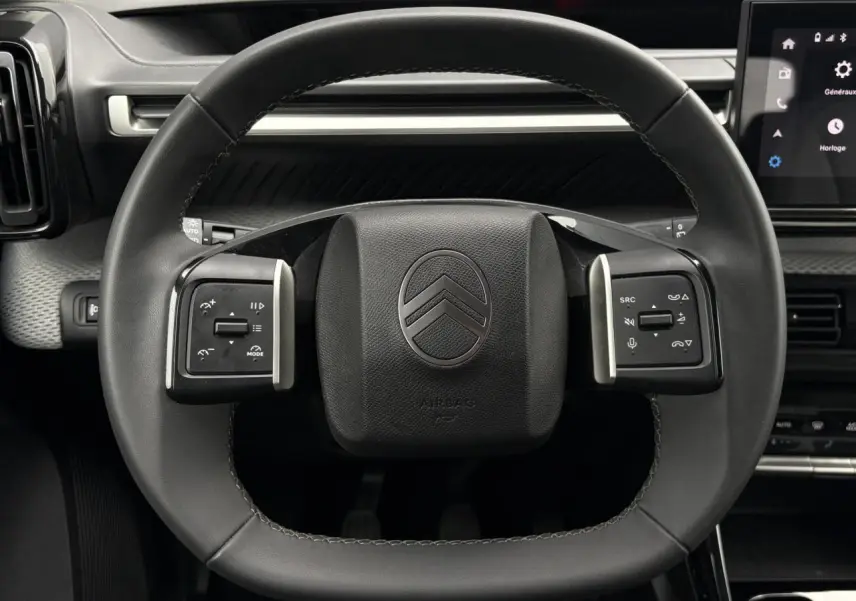 Vue rapprochée du volant noir de la Citroën C3 Turbo 100 Max 2025 avec commandes intégrées et tableau de bord partiel.