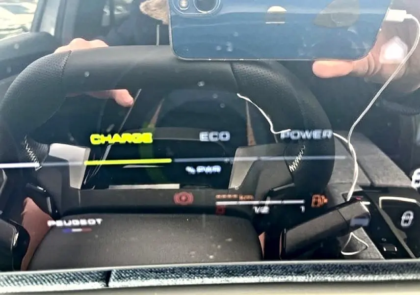 Vue rapprochée du tableau de bord numérique et volant cuir noir du Peugeot 3008 hybride gris titane.