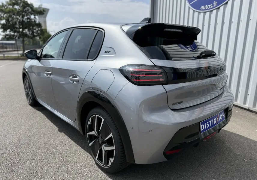 Peugeot 208 Hybrid 145 GT gris Artense vue 3/4 arrière droit avec jantes noires et logo GT sur l'aile.