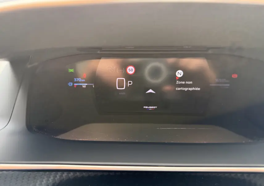 Tableau de bord numérique du Peugeot 208 Hybrid 145 GT, affichant la vitesse à 0 et une zone non cartographiée.