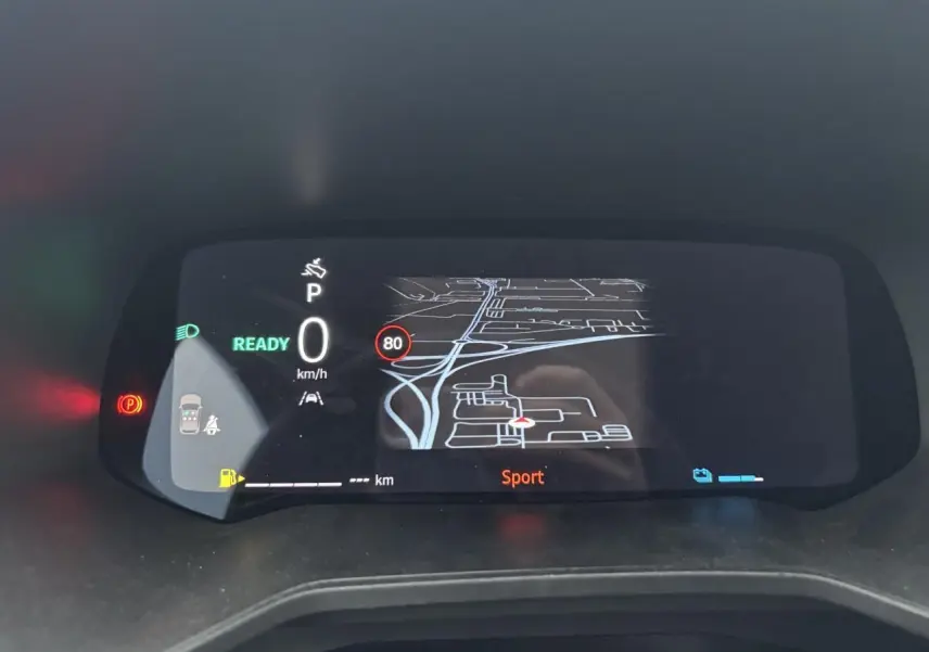 Tableau de bord numérique de Renault Clio 2025 affichant la navigation et mode Sport, vu de face en intérieur.