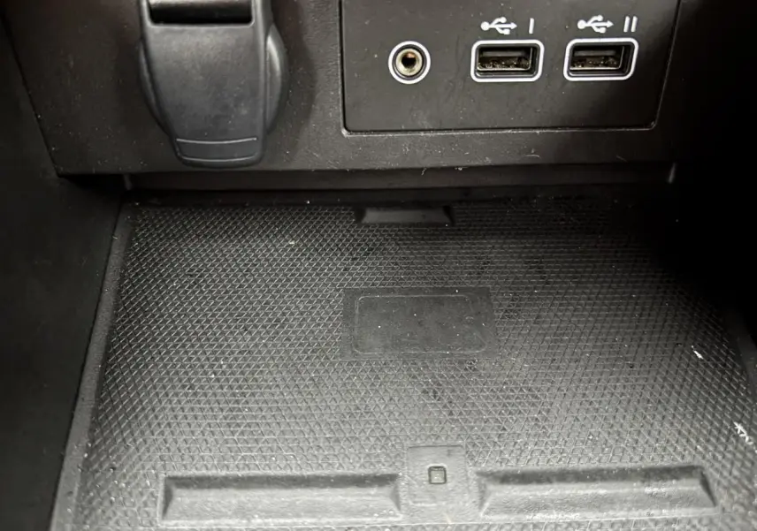 Gros plan sur la console centrale noire avec ports USB et prise jack dans une Renault Clio rouge flamme 2025.