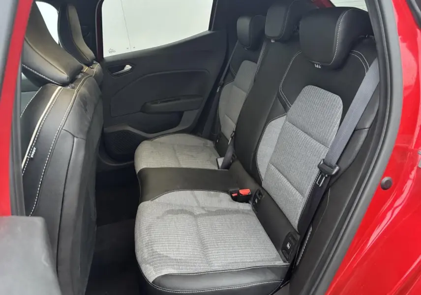 Vue côté droit de la banquette arrière grise et noire de la Renault Clio V rouge Flamme, avec ceinture et fixation ISOFIX visibles.