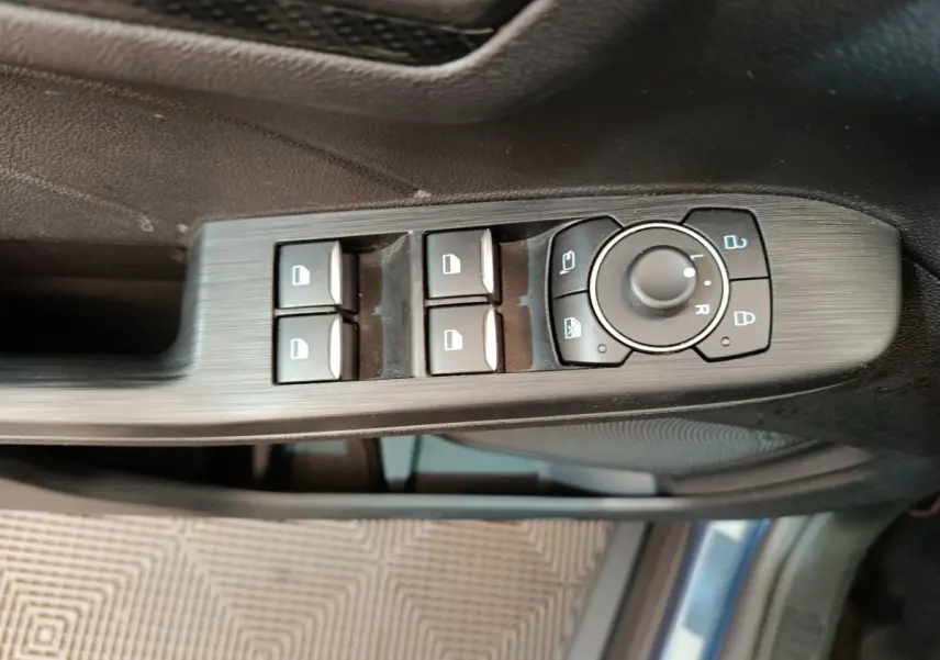 Panneau de commande des vitres et rétroviseurs côté conducteur du Ford Kuga bleu 2024 St Line.