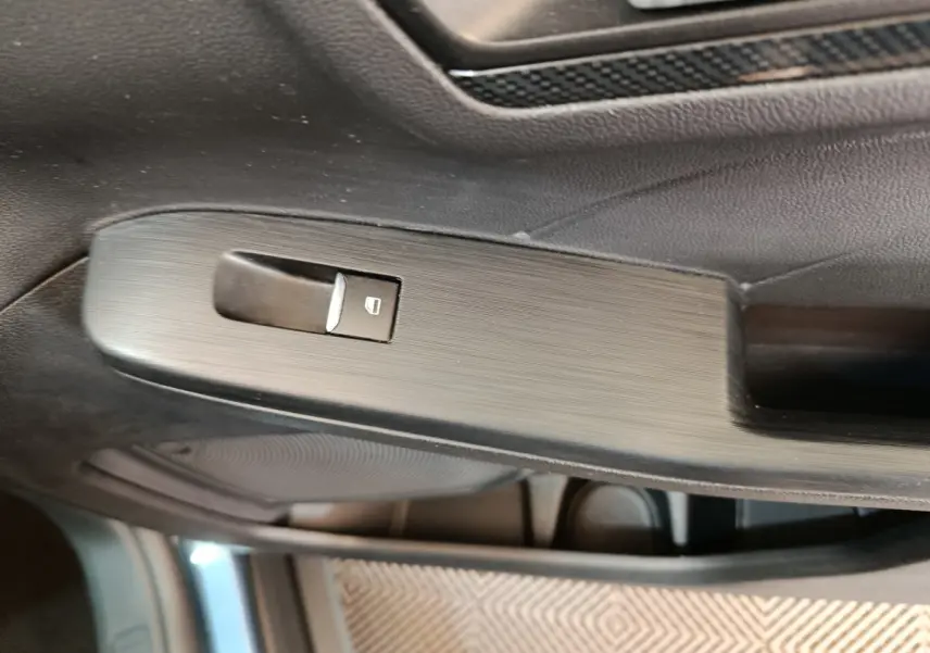 Bouton de verrouillage de fenêtre sur la porte côté gauche intérieure du Ford Kuga bleu 2024 St Line.