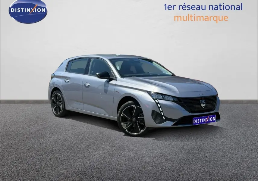 Peugeot e-308 gris Artense vue 3/4 avant droit, avec jantes alliage noires et feux LED verticaux distinctifs.