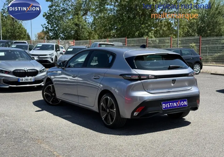 Vue 3/4 arrière droite de la Peugeot e-308 gris Artense avec feux arrière LED et jantes alliage noires.