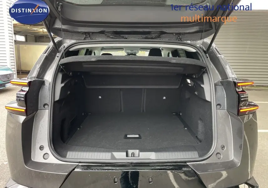 Vue arrière du coffre ouvert d'un Citroën C5 Aircross Hybrid gris platinium métal, avec feux arrière allumés en LED.