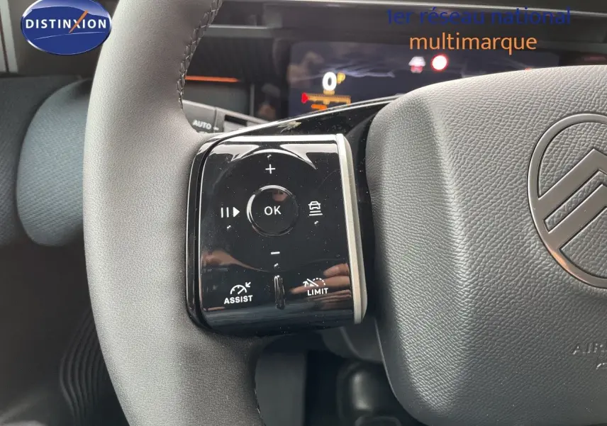 Gros plan sur le volant gris avec commandes multifonctions et logo Citroën, intérieur du C5 Aircross Hybrid 2026.