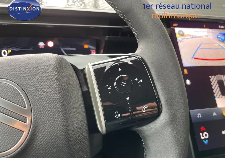 Gros plan sur le volant cuir noir de la Citroën C5 Aircross Hybrid 2026 avec commandes tactiles et écran multimédia en arrière-plan.