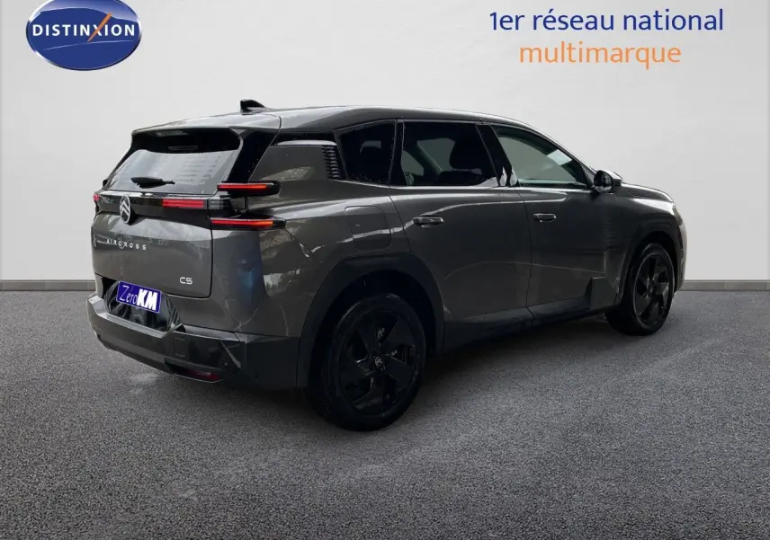 Vue 3/4 arrière droite d'un Citroën C5 Aircross Hybrid gris platinium métallisé avec jantes noires et toit noir.