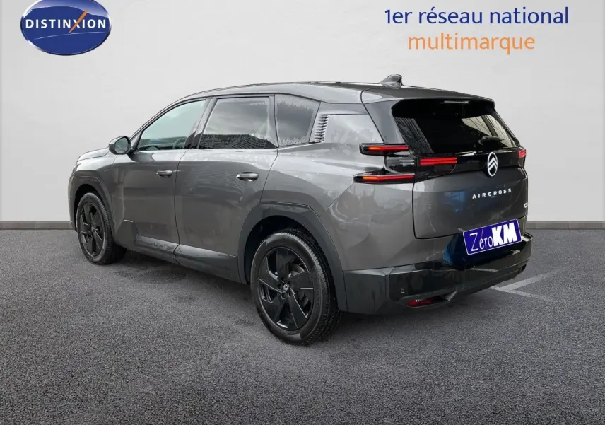 Vue 3/4 arrière droite d'un Citroën C5 Aircross Hybrid gris platinium métallisé avec jantes noires et feux arrière LED fins.