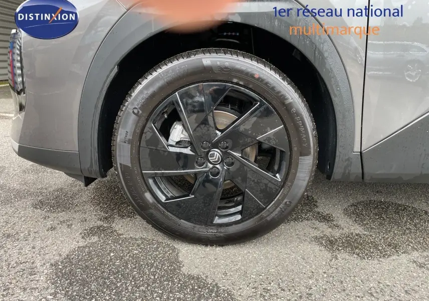 Gros plan sur la roue avant droite noire brillante d'un Citroën C5 Aircross gris platinium métallisé.