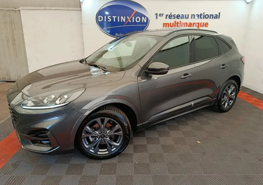 Ford Kuga 2024 gris clair en vue 3/4 avant droit, avec jantes alliage foncé et rétroviseurs assortis.