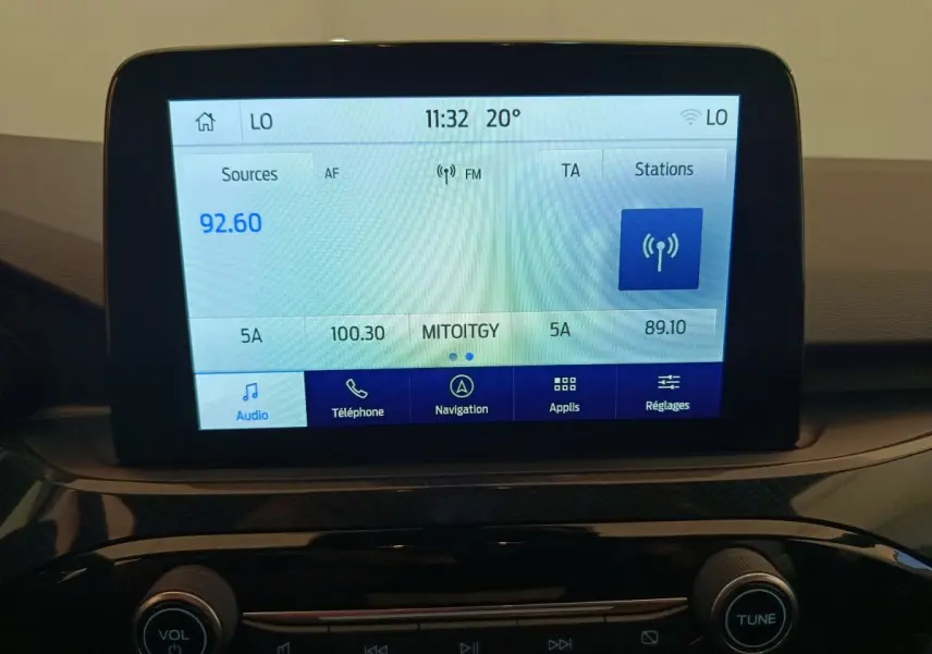 Écran tactile central du tableau de bord du Ford Kuga 2024 affichant la radio FM et les options multimédia.