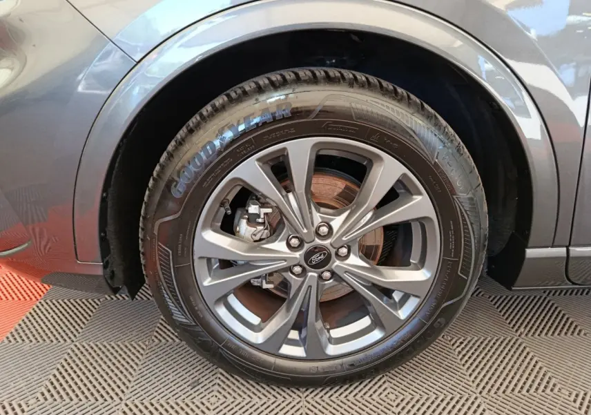 Gros plan sur la roue avant gauche gris clair du Ford Kuga 2024 avec jante alliage et pneu Goodyear.