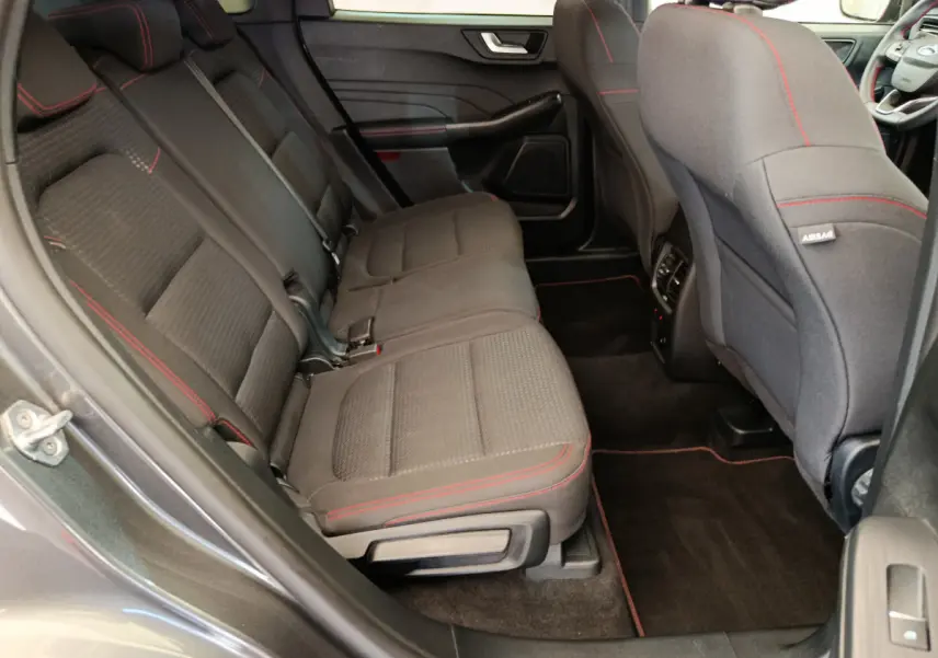 Vue côté gauche de la banquette arrière noire avec surpiqûres rouges du Ford Kuga 2024 finition St Line.