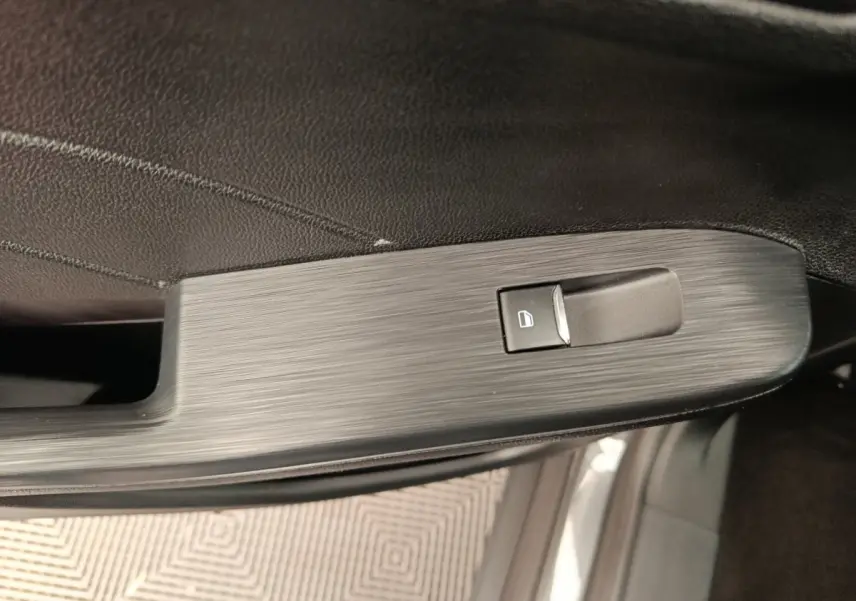 Bouton de verrouillage de porte sur la garniture intérieure noire côté gauche du Ford Kuga gris clair 2024 St Line.