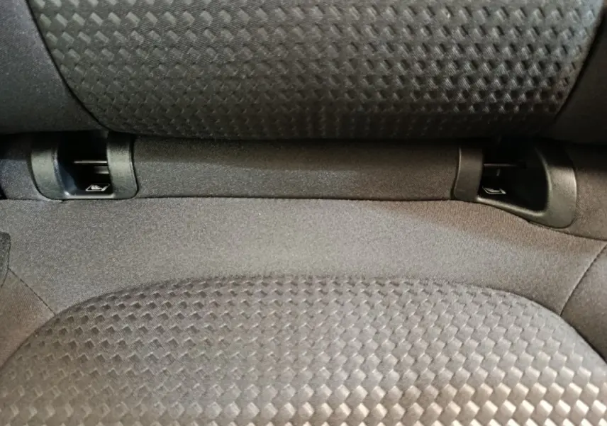 Gros plan sur l'assise arrière grise texturée du Ford Kuga 2024, montrant les fixations Isofix intégrées.