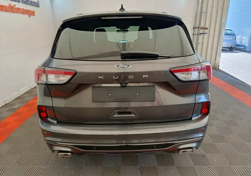 Vue arrière d'un Ford Kuga gris clair 2024 avec feux LED et double sortie d'échappement intégrée au pare-chocs.