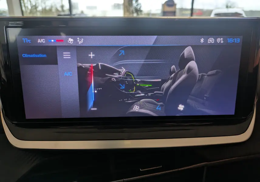 Écran tactile affichant la climatisation avec vue latérale intérieure des sièges et du volant cuir du Peugeot 208 noir perla.