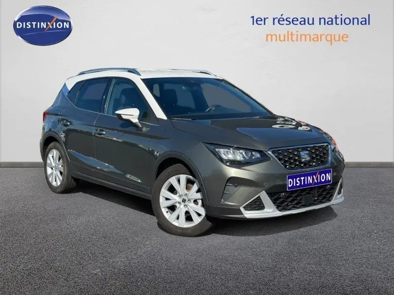 Vue 3/4 avant d’un SEAT Arona noir avec jantes alu blanches et calandre distinctive, sur fond neutre.