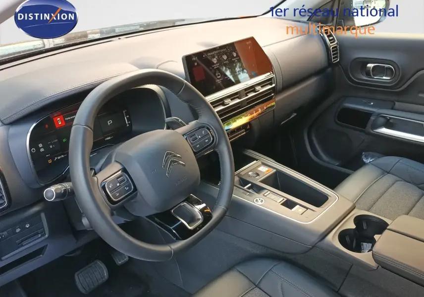 Vue intérieure côté conducteur du Citroën C5 Aircross gris platinium, avec tableau de bord numérique et volant cuir noir.