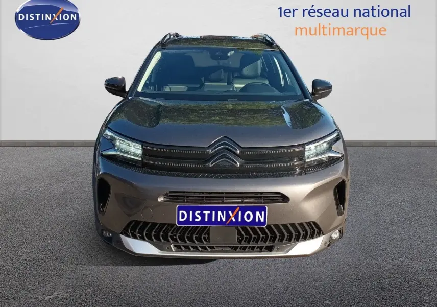 Vue frontale du Citroën C5 Aircross gris platinium métal 2025 avec calandre distinctive et feux LED allumés.