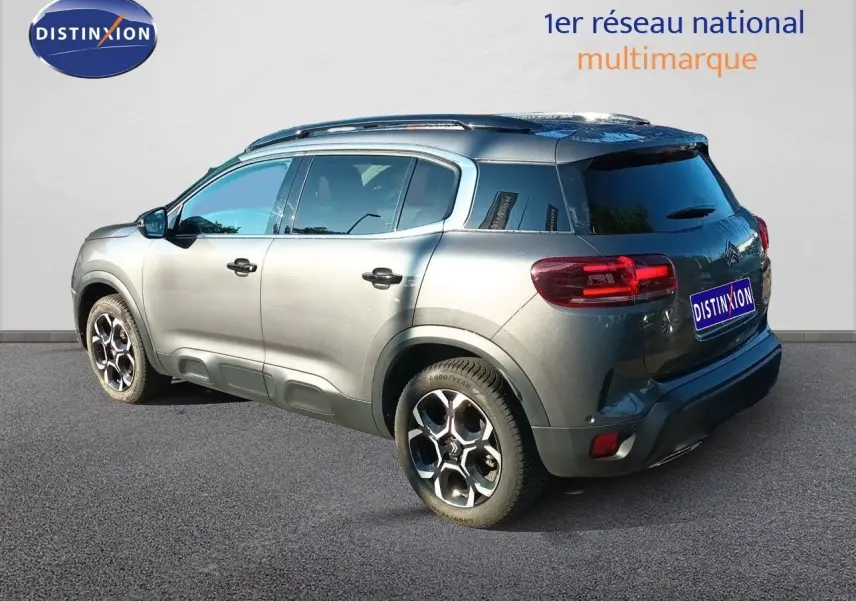 Citroën C5 Aircross gris platinium métal vue 3/4 arrière côté droit, avec jantes bi-ton et vitres teintées.