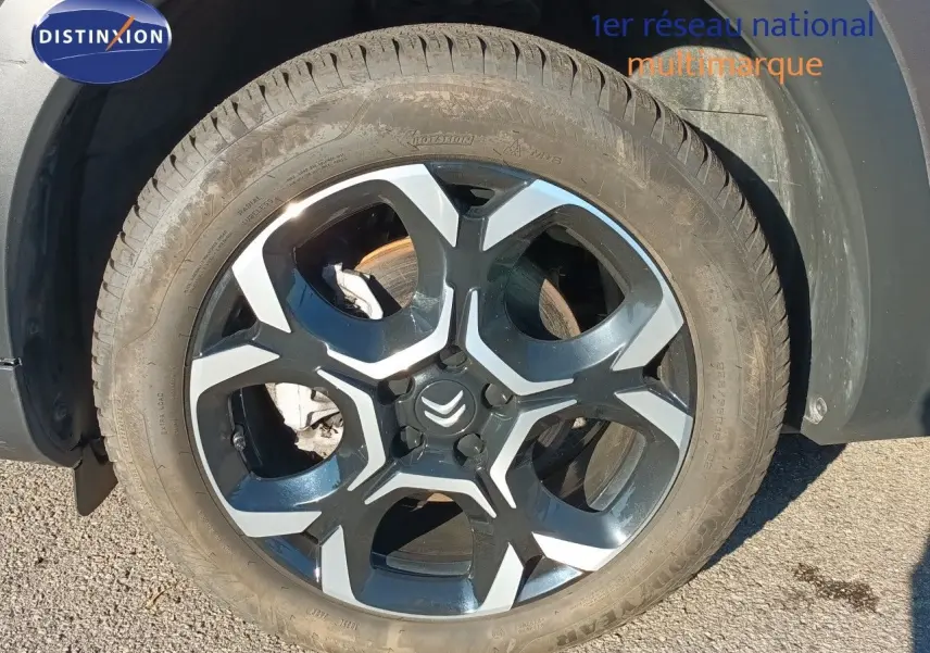 Gros plan sur la roue avant droite du Citroën C5 Aircross gris platinium avec jante alliage bicolore.