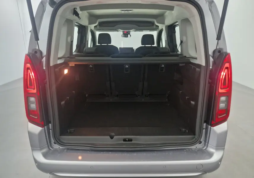 Vue arrière ouverte du coffre d'un Opel Combo Life gris Artense, montrant les trois sièges individuels en rang 2 et l'espace de chargement.