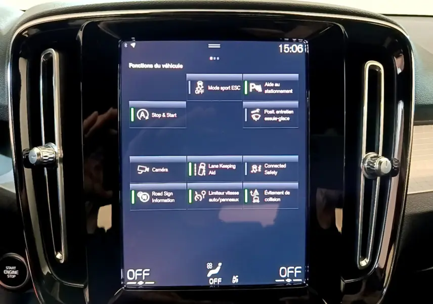 Écran tactile central affichant les fonctions d’aide à la conduite du Volvo XC40 T2 gris clair, vue de face rapprochée.