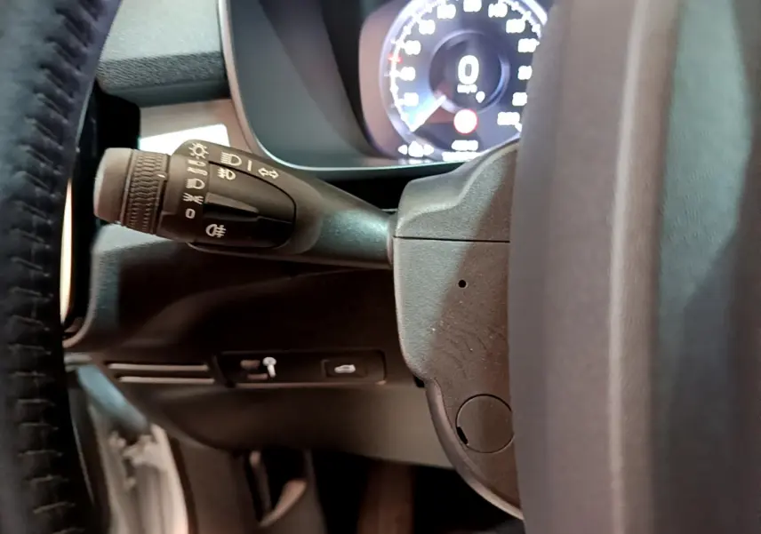 Gros plan sur la manette des feux et le tableau de bord numérique du Volvo XC40 T2 Momentum gris clair de 2020.