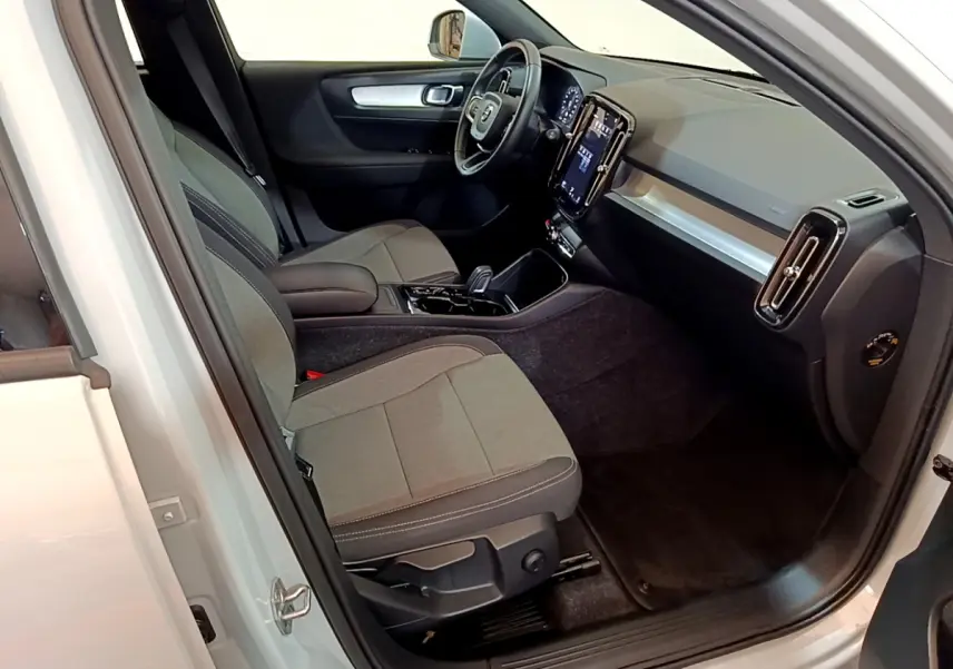 Intérieur côté conducteur du Volvo XC40 gris clair 2020, avec tableau de bord moderne et sièges tissu gris.