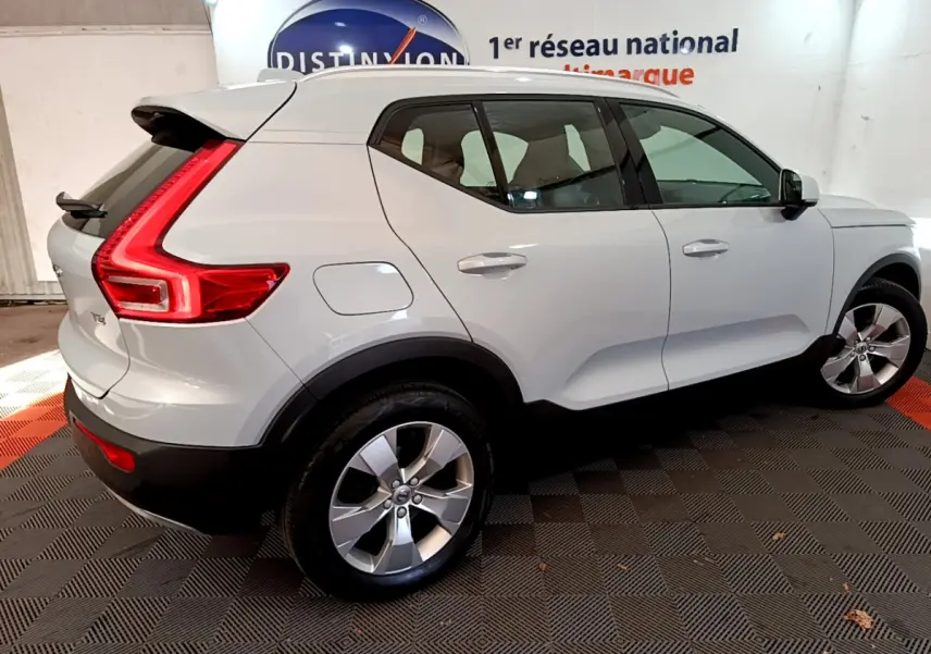Vue 3/4 arrière droite d'un Volvo XC40 T2 gris clair avec feux arrière LED en forme de C et jantes alliage.