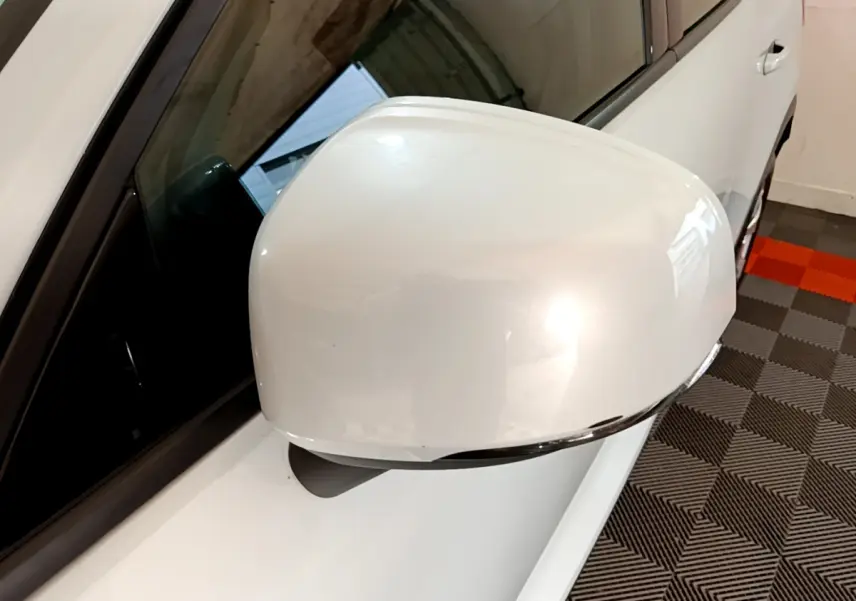 Rétroviseur côté gauche blanc brillant du Volvo XC40 T2 129 Momentum 2020, avec carrosserie gris clair visible en arrière-plan.