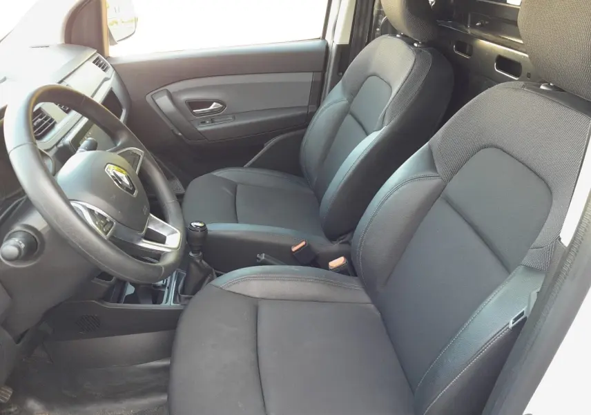 Vue intérieure côté conducteur du Renault Express Van 2023, sièges noirs et volant avec logo Renault visible.